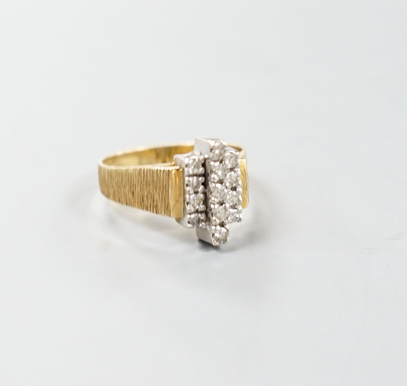 A 1970's textured 18ct gold and thirteen stone diamond set geometric dress ring, size Q, gross weight 5.3 grams.